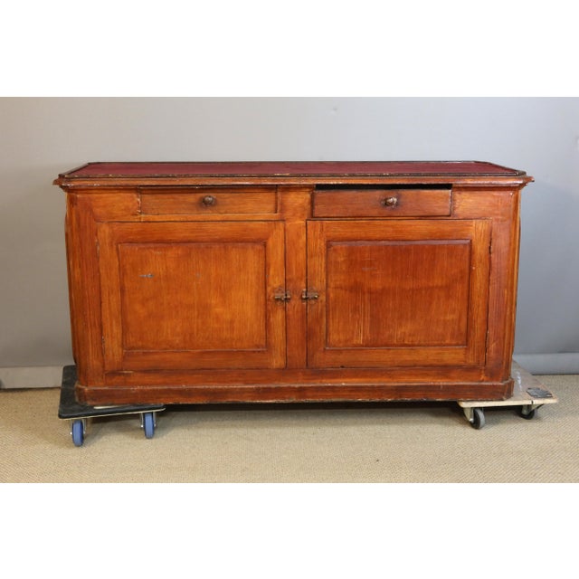 Painted pitch pine counter with a display case. The front is glazed and the back opens with two doors and two drawers. The...