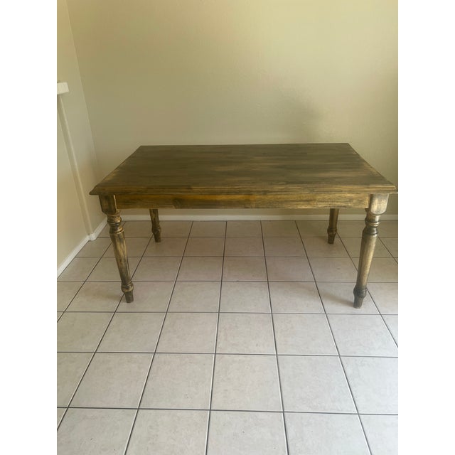 “Beautiful dining table. Features a solid wood butcher-block style top with a rich, warm finish and classic turned legs....