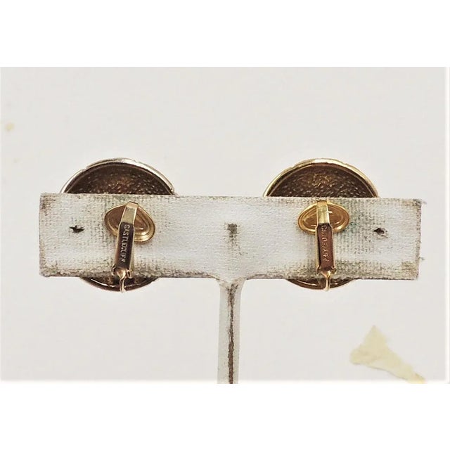 This is part of Chairish’s Costume Jewelry assortment. 1960s goldtone round domed pink rhinestone clip earrings. Marked...