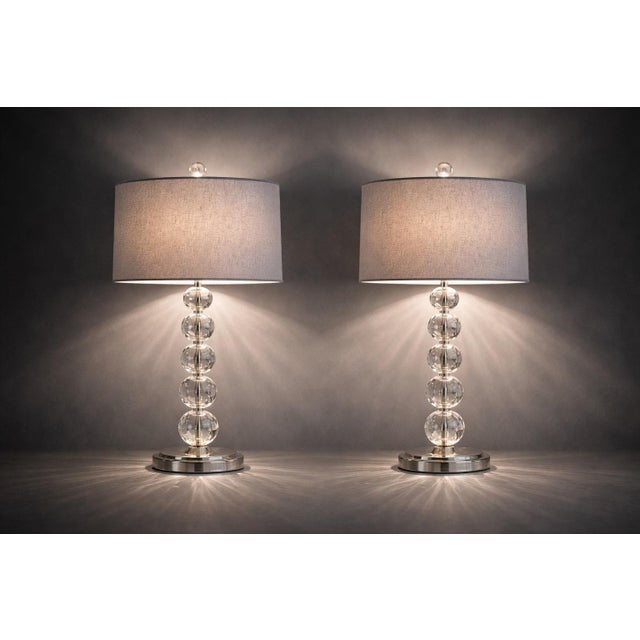 A stately pair of late 20th century Hollywood Regency revival table lamps featuring stacked faceted crystal-style spheres...