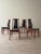 Set of four dining chairs with figured rosewood frames and black vinyl upholstered seats and backs. Each chair features a...