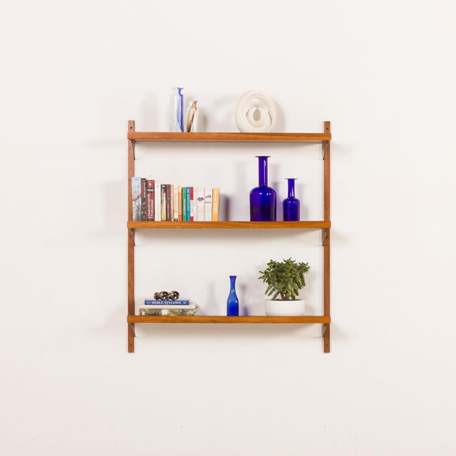 A minimalist, mid-century shelving unit in teak comes from denmark and is dated most likely to the 1970s. The shelves have...