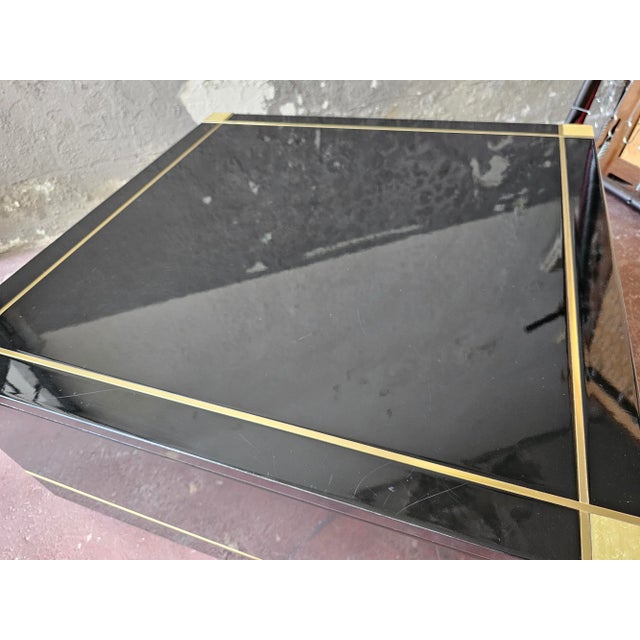 Elegant coffee table made of black lacquered wood. Gorgeous brass finishes. Excellent state of conservation, however with...