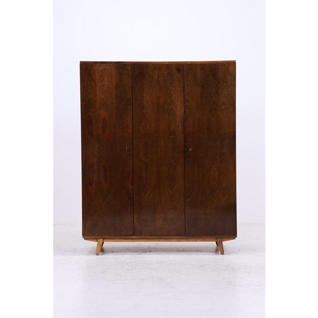 Vintage wardrobe with a striking grain and clean mid-century design. The combination of clothes rail, shelves, and drawers...