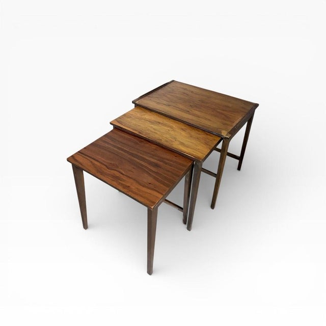 A beautifully proportioned Gordon Russell walnut nest of tables, showcasing the refined craftsmanship and understated...