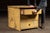 Compact painted utility cabinet with three graduated drawers, finished in a heavily worn mustard-yellow paint that has...