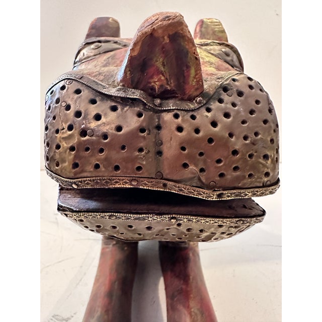 This expressive hand‑carved wooden sculpture depicts a stylized animal, likely a feline, rendered with bold form and...