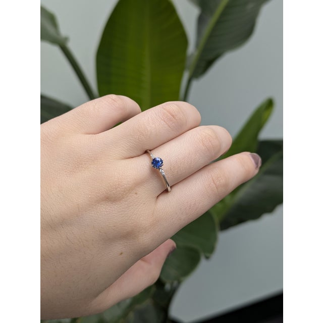 This delicate ring features a 0.43-carat round AAA Ceylon sapphire, measuring 4mm, known for its vibrant blue hue and...