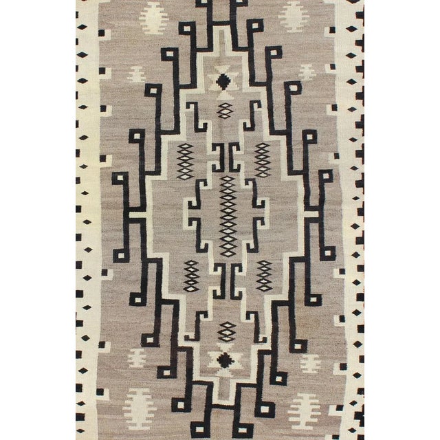 This intriguing Navajo style rug was woven in the United States during the first half of the 20th century. The exciting...