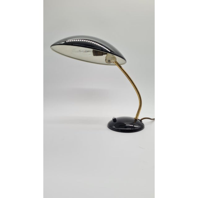 The 6781 table lamp, designed by Christian Dell for Kaiser Idell in the 1950s, combines a semicircular shade with a...