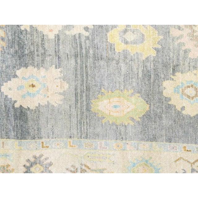 This Vintage Turkish Oushak Rug is a handwoven masterpiece from Western Turkey, measuring 10'7" x 13'11". Oushak has been...