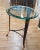 Maitland-Smith occasional glass top table. The piece is made of steel finished iron and features a glass top and brass...
