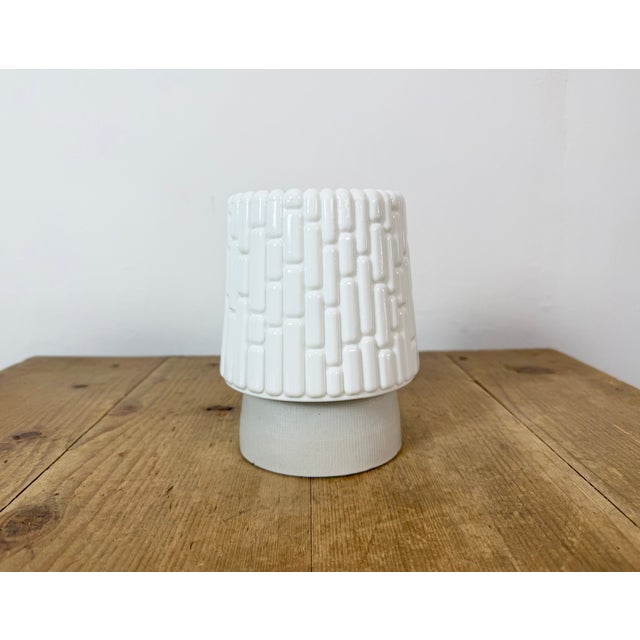 Vintage industrial ceiling or wall light made in former Czechoslivakia during the 1970s. It features a white porcelain...