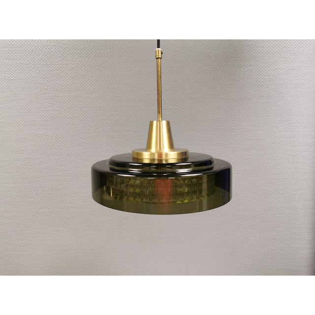 Rotonda hanging lamp with an outer shade of green glass, an inner shade of transparent crystal glass and a brass top...