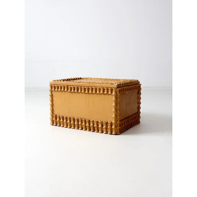 This antique folk art spool trunk, dating to the early 20th century, features a charming butterscotch-painted wood...