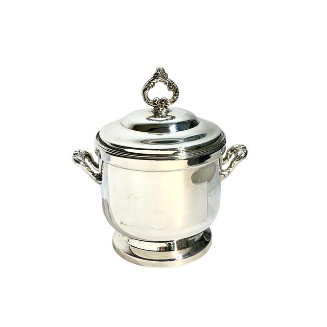 A timeless vintage Oneida ice bucket, crafted in polished silverplate with elegant side handles and a decorative finial...