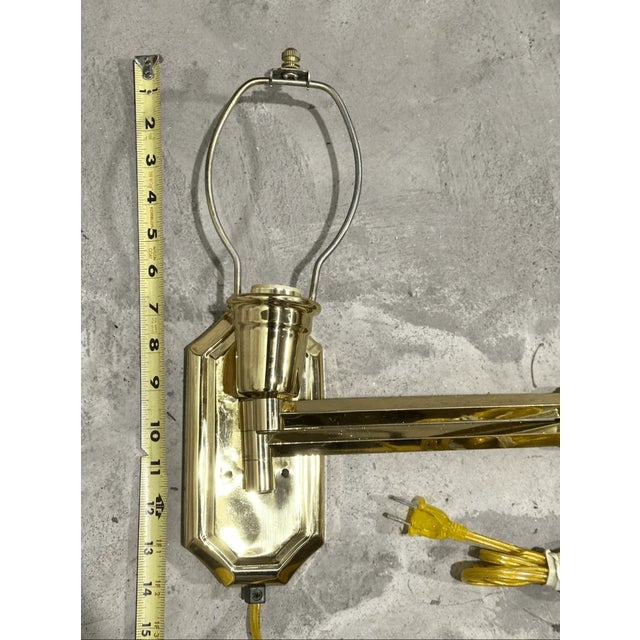 Good condition Add a touch of classic elegance and functional lighting to your space with this polished brass swing-arm...