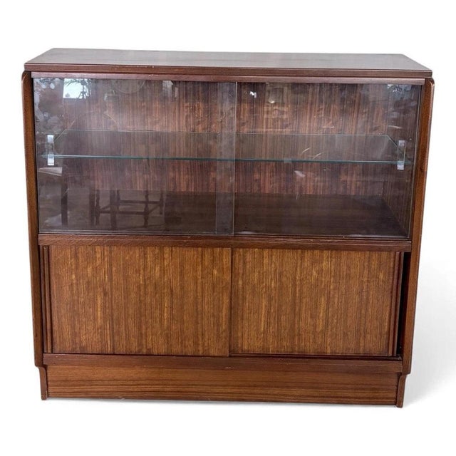 This vintage sliding door bookcase is a classic mid century wooden display cabinet designed to provide stylish and...
