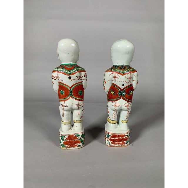 CHINA, Kangxi period, 18th century. Pair of porcelain figures depicting the twin brothers Hoho Erxian standing on...