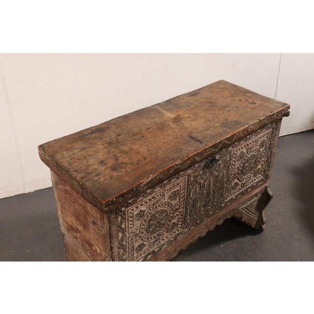 A Moorish carved and raised wood trunk from the 19th century. This antique chest from Tunisia has been designed in an...