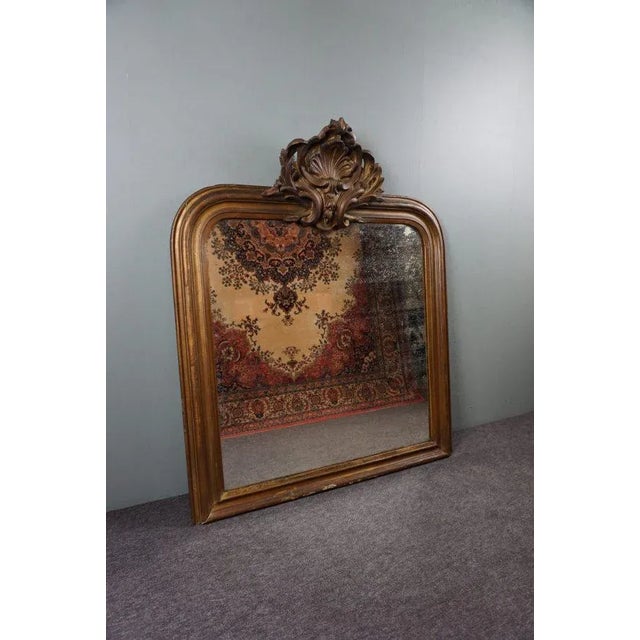 Beautiful lived large antique French mirror with beautifully large centered ornament. This fireplace mirror from the...
