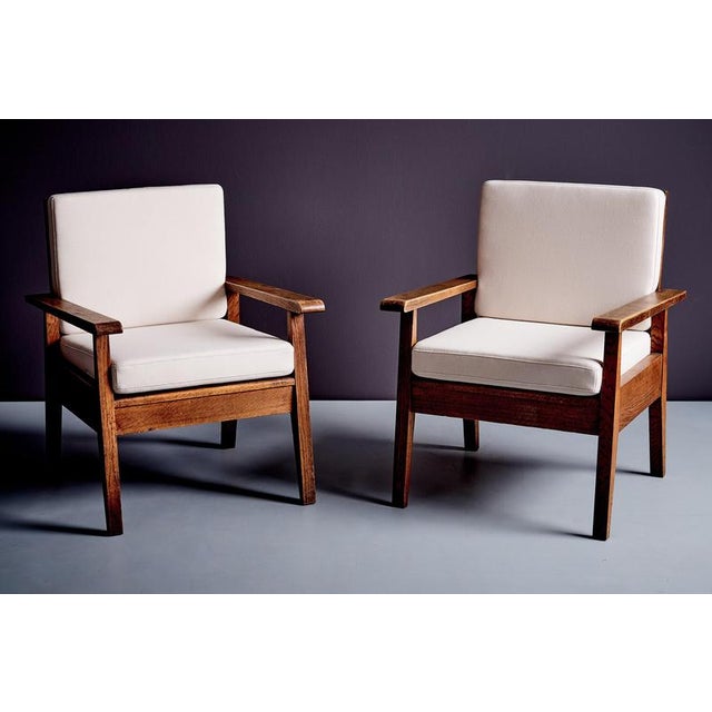 A pair of mid-century lounge chairs in the manner of René Gabriel, constructed with solid oak frames and defined by...