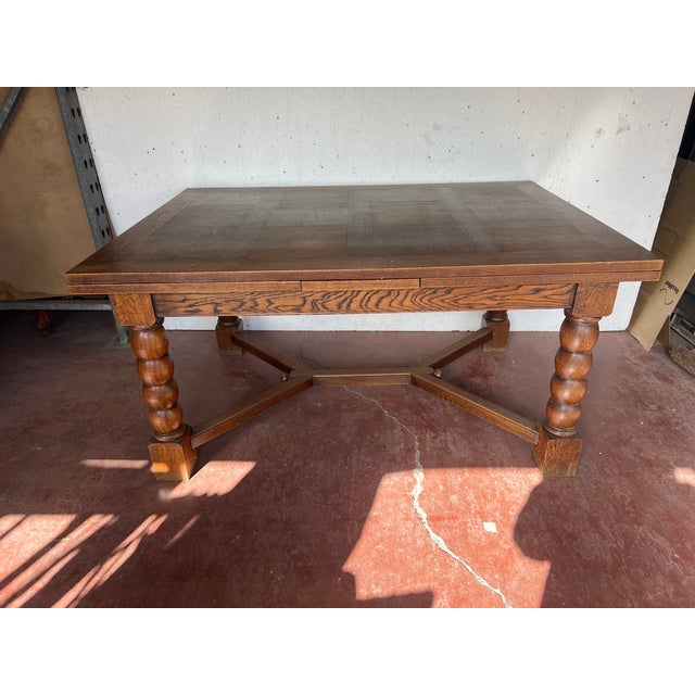 Renaissance-style table in solid oak and veneer Four turned legs joined by an X-shaped stretcher Two Italian-style...