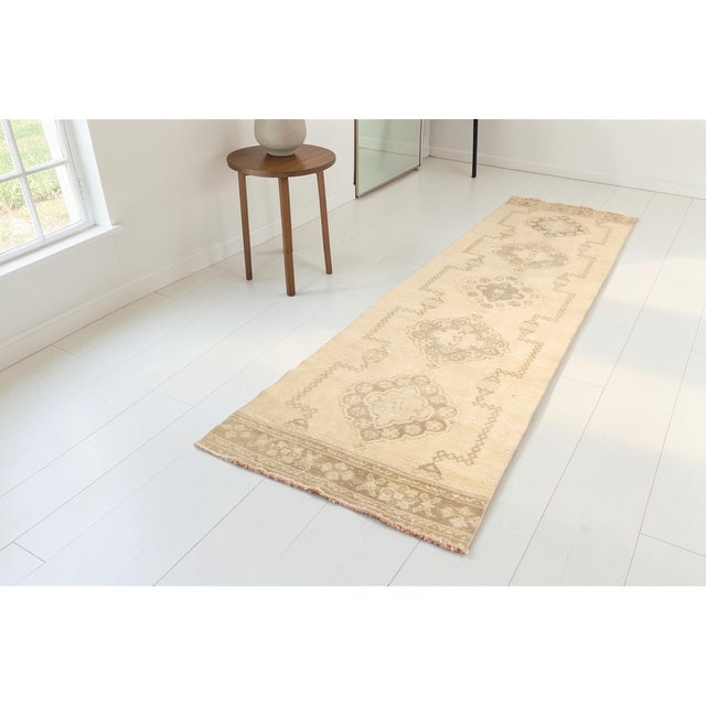 This is a vintage Turkish Oushak rug from the Mid 20th Century. The piece was hand-knotted.