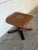 This vintage tan leather ottoman features a sculptural wooden base with sweeping arched legs. The plush cushioned top...