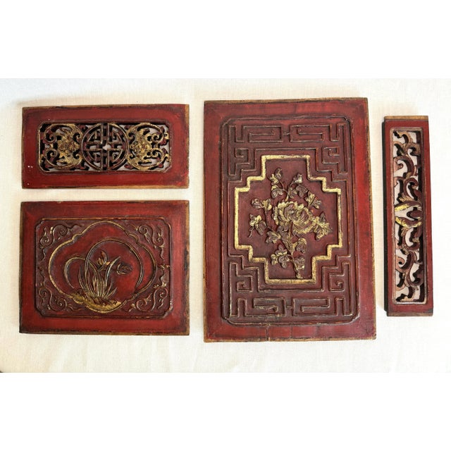 An antique set of ornately carved Chinese teak wood plaques. The set of four are in various sizes depicting with intricate...