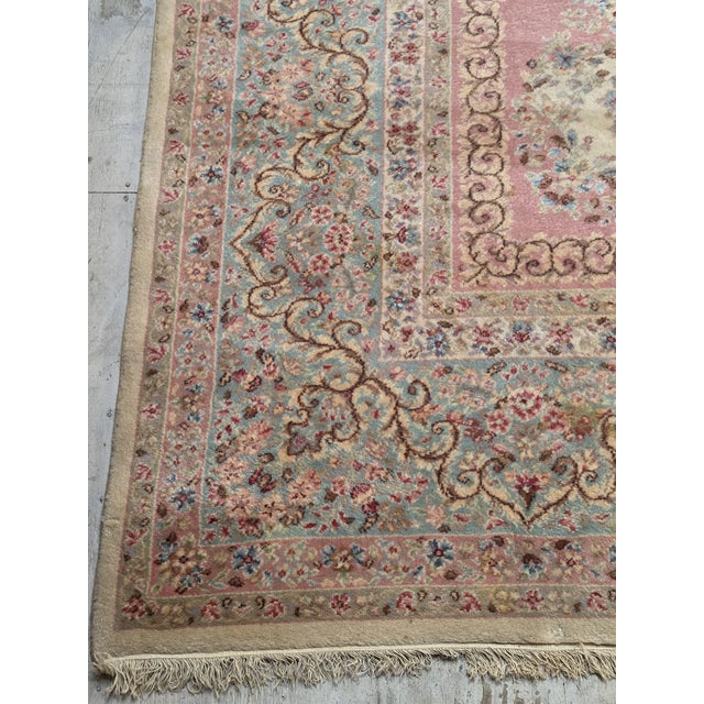 oversized vintage Persian-style rug featuring a soft ivory field, dusty rose accents, and powder blue detailing. This...