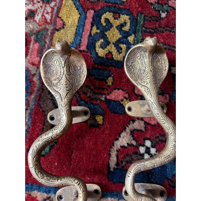 This is a pair of striking Vintaged gold brass cobra door handles with incised decoration in the Hollywood Regency and...