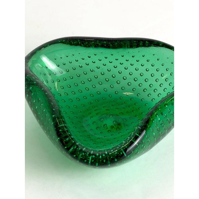A 1960s Italian Murano glass bowl by Seguso, distinguished by its rich green colouring, shallow triangular form and...