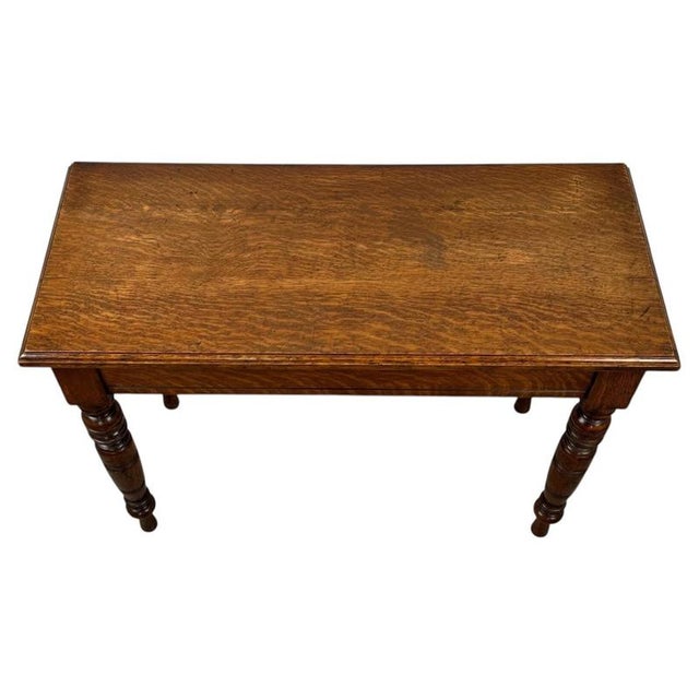 A handsome early 20th-century English side table, finely crafted from oak and distinguished by its elegant proportions,...