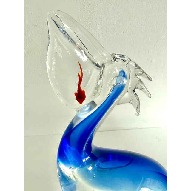 Beautiful blown art glass pelican sculpture, after the Murano glass maestro Oscar Zanetti. Features a cheeky red fish...