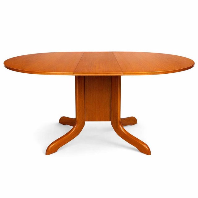 A classic teak drop-leaf dining table by Morris of Glasgow, combining elegant craftsmanship with practical flexibility....