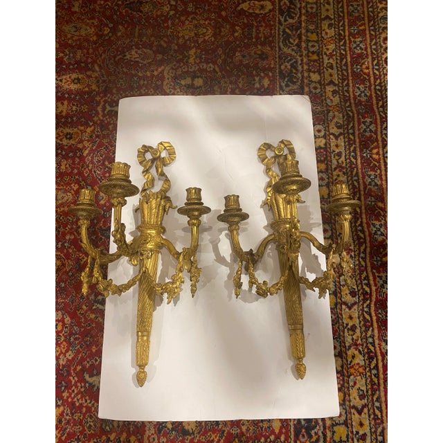 A pair of circa 1900 Caldwell gilt bronze sconces with ribbons and flowers design, 3 lights