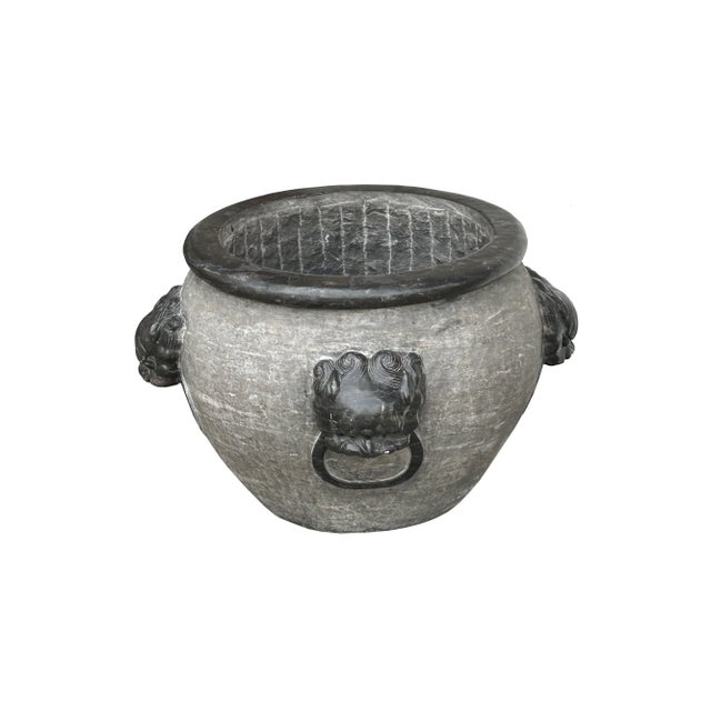 This is a Chinese stone carved round water pot/planter in gray black color. The rim and foo dogs heads are in darker...