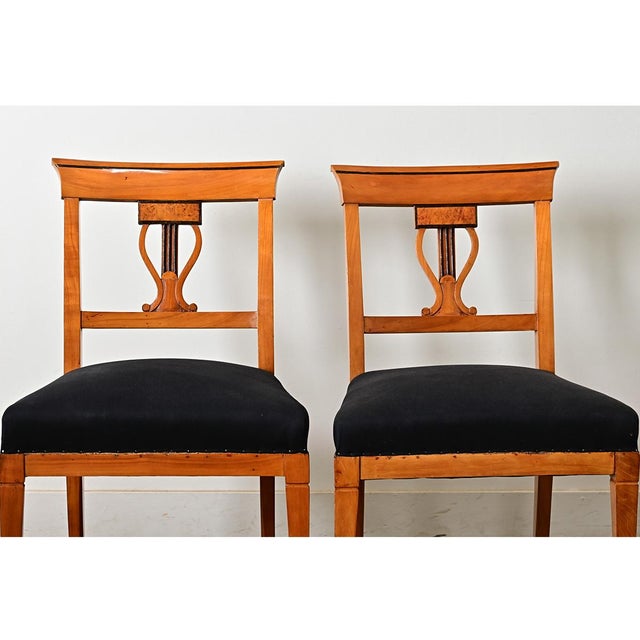 A restrained pair of German Biedermeier side chairs, circa 1820, in that timeless combination of light wood and ebonized...