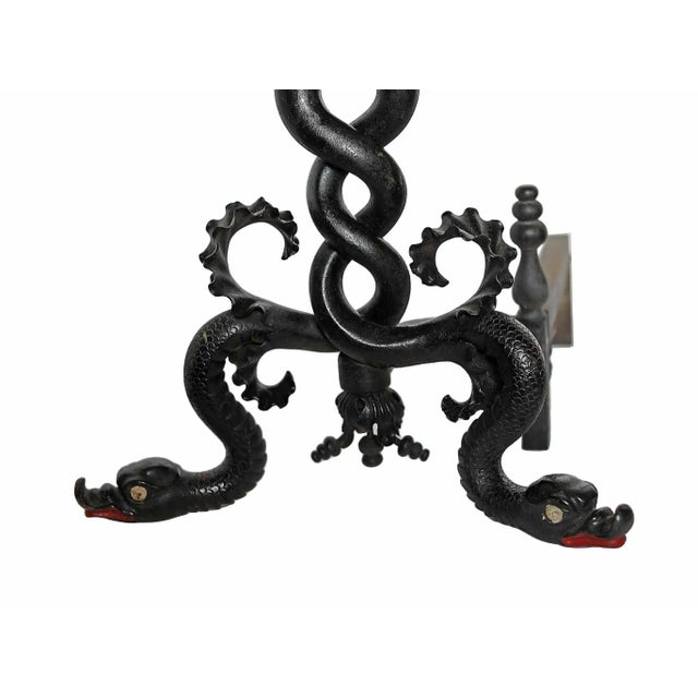 Rare and interesting pair of Arts and Crafts style wrought iron andirons. Intertwining serpentine form shafts terminate in...