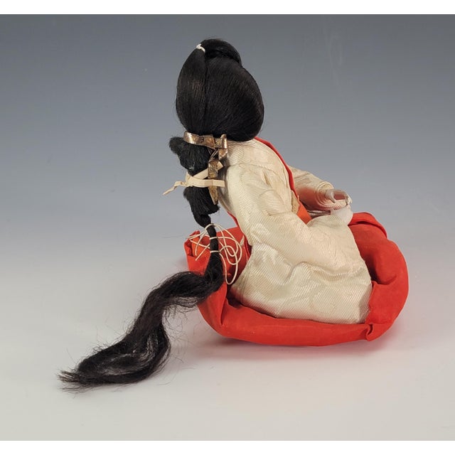 A finely crafted Japanese Hina Matsuri doll representing a traditional court lady attendant, executed in classic materials...