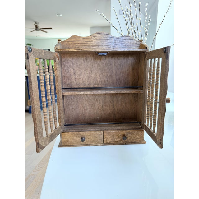 A charming and decorative Victorian oak wall cabinet with turned spindle doors — equal parts functional storage and...