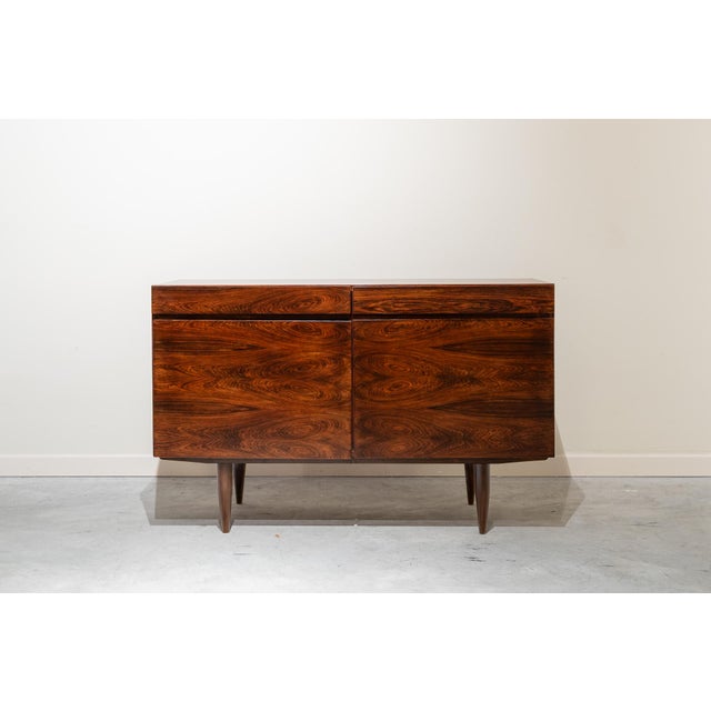 Nordic rectangular sideboard with two drawers and two doors with interior shelves, mounted on four tapered wooden legs,...