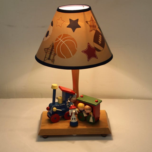 Vintage wooden table lamp/nightlight with music box by Nursery Original Inc. Design features a colorful wooden toy train...