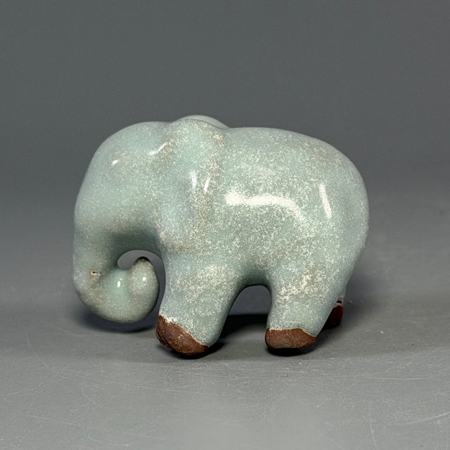 This antique Chinese ceramic elephant figurine is covered in soft celadon glaze with natural crackle. A charming small...