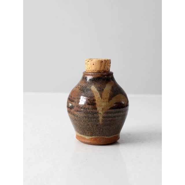 Signed by the artist, this vintage studio pottery jar makes a lovely decorative kitchen bottle. The handmade jar features...