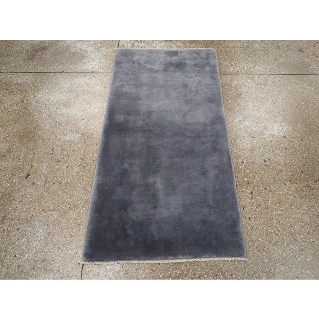This mid-20th century Chinese Art Deco rug, showcases a minimalist yet sophisticated design. Featuring a solid blue field...