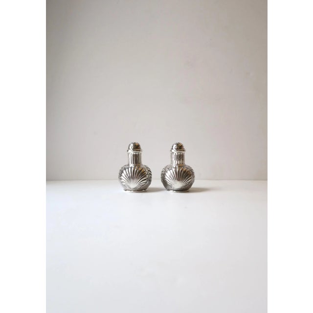 A beautiful and well-made pair of Sterling Silver salt and pepper shakers with scallop seashell design by iconic American...