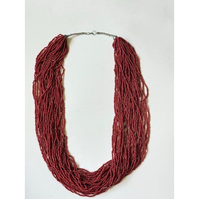 Old pawn seed bead necklace in the best shade of persimmon red. Thirty strands and thousands of glass beads makes this...