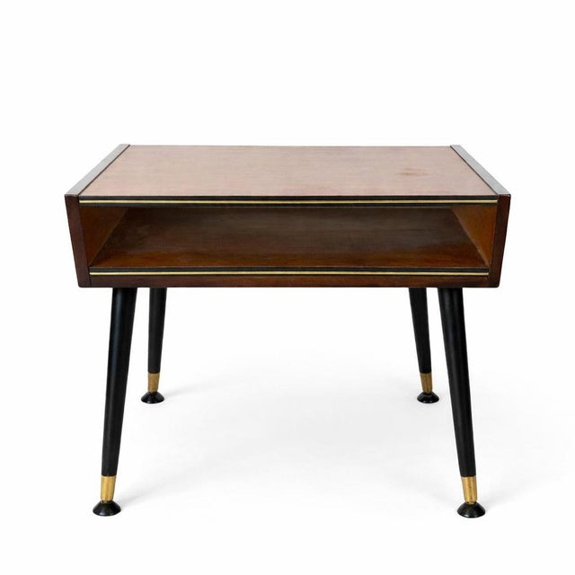 A striking atomic-era bedside table or side table, featuring clean mid-century lines and classic space-age styling. The...